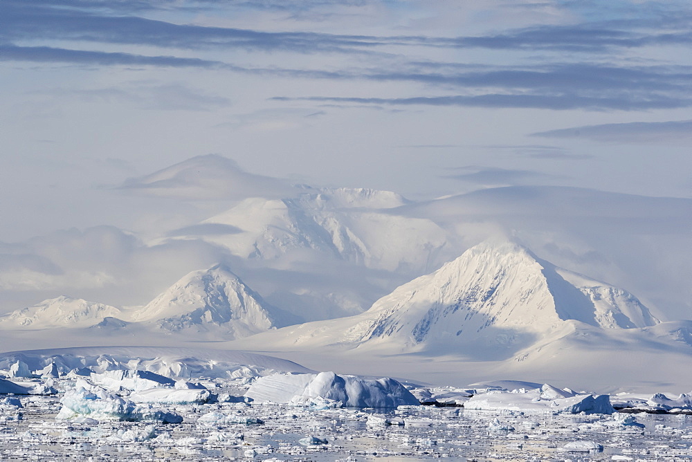 Snow-covered mountains line the ice floes in Penola Strait, Antarctica, Polar Regions