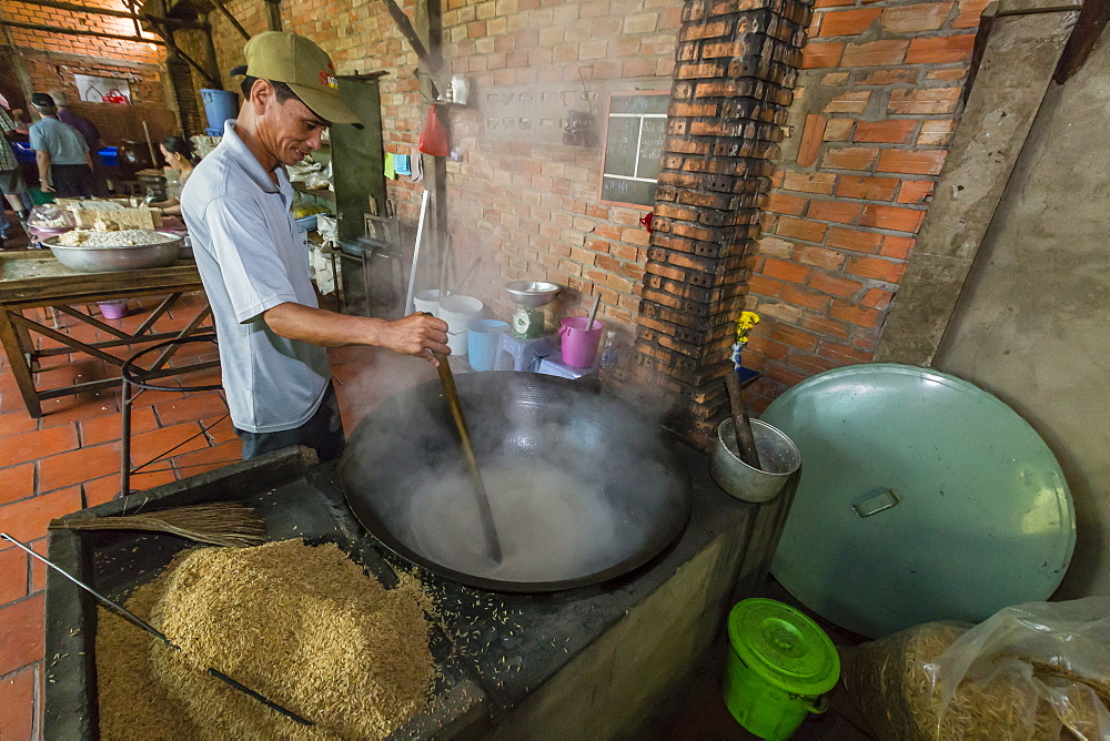 Man making palm sugar rice candy over fire at Cai Be, Vietnam, Indochina, Southeast Asia, Asia