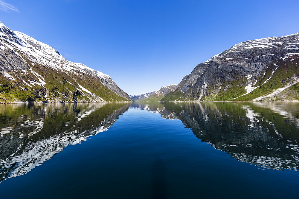 Snow-capped mountains reflected in the calm waters of Nordfjord, deep inside of Melfjord, Norway, Scandinavia, Europe