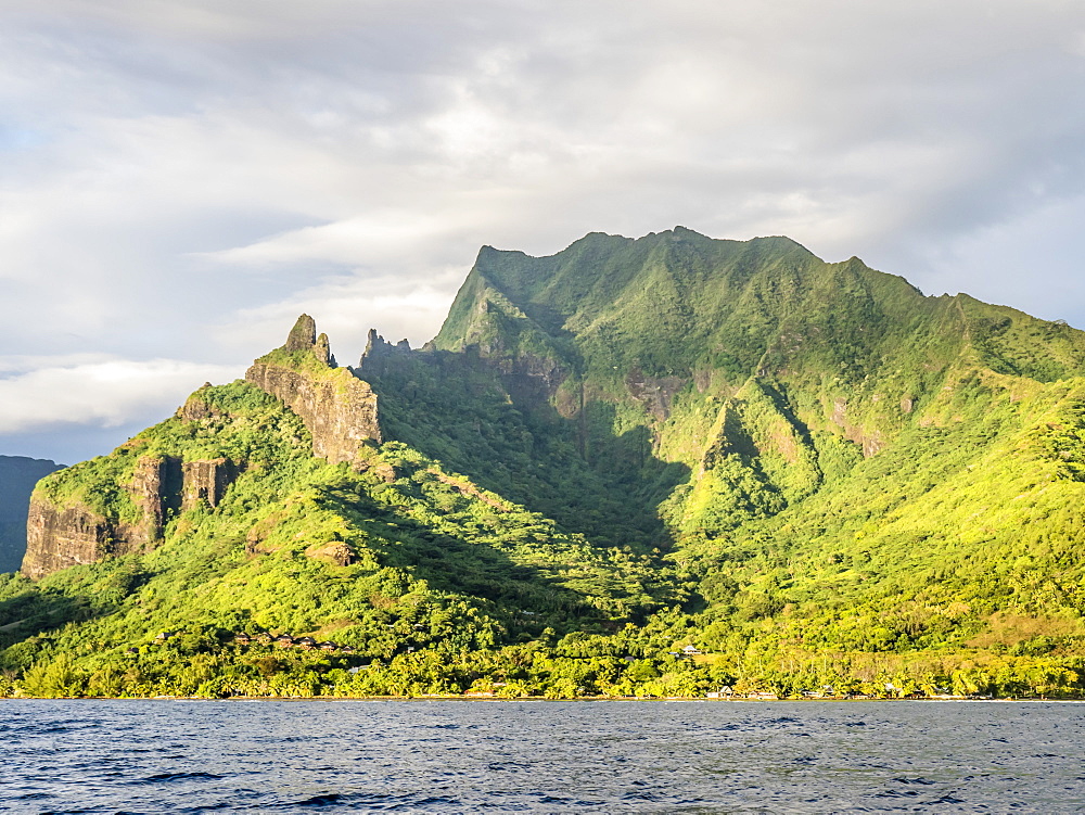 Sunrise approach to Cook Bay with the jagged outline of Mount Rotui, Moorea, Society Islands, French Polynesia, South Pacific, Pacific