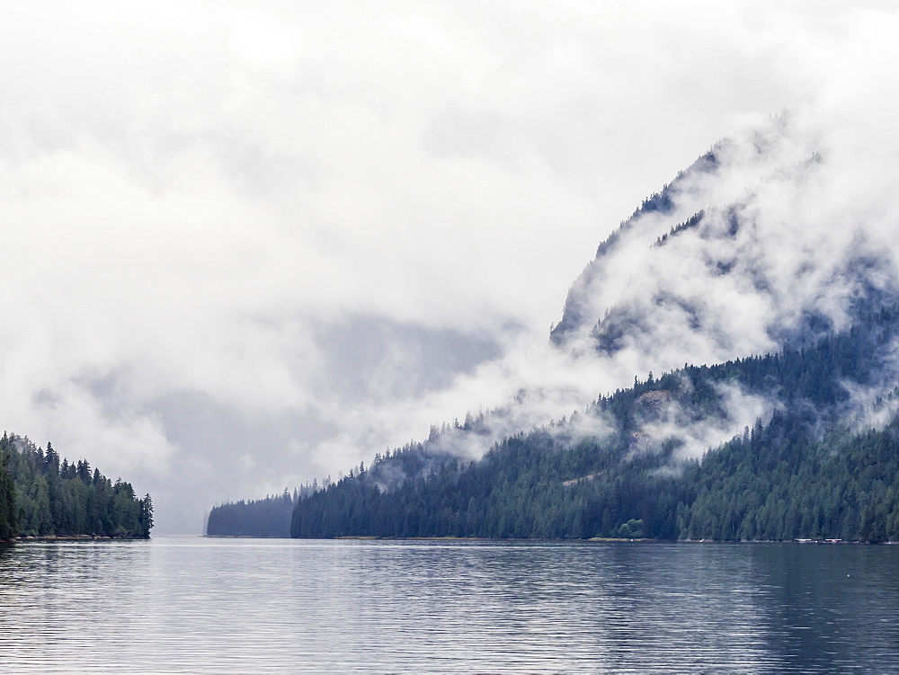 Low lying clouds shroud the mountain tops in Misty Fjords National Monument, Southeast Alaska, United States of America