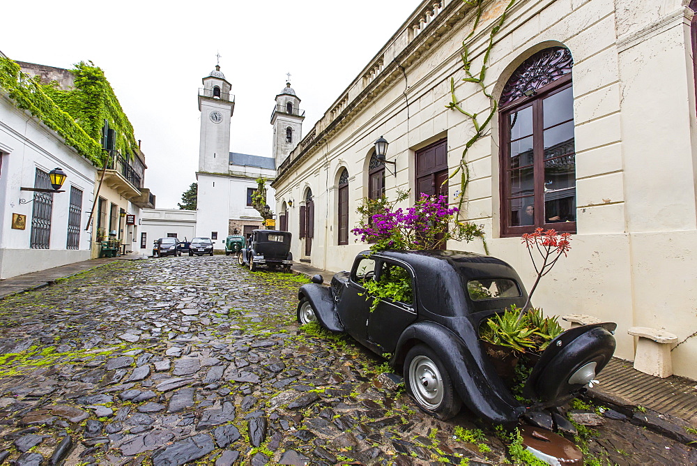 Old car turned into planter on cobblestone street in Colonia del Sacramento, Uruguay, South America