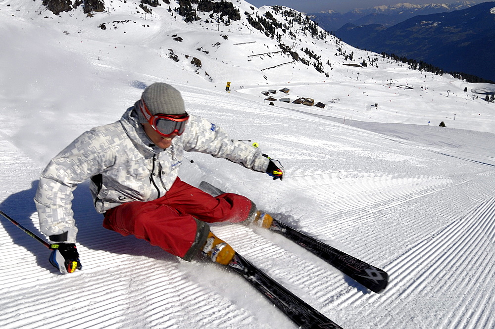 Skier on snowy ski slope in the sunlight, Zillertal, Tyrol, Austria, Europe