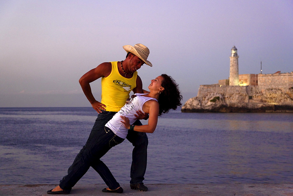 Couple dancing salsa, Castillo de los Tres Reyes del Morro in background, Havana, Ciudad de La Habana, Cuba, West Indies