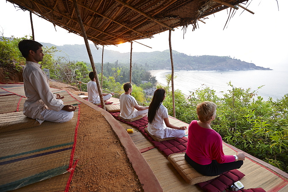 Meditation before sunrise above Om beach, Gokarna, Karnataka, India