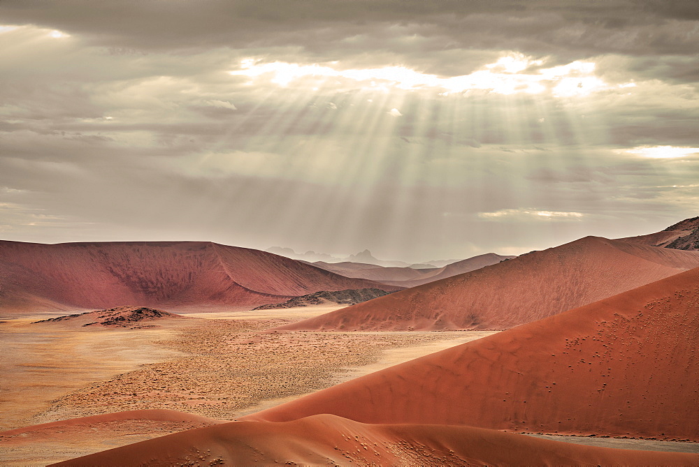 view from Dune 45 to the landscape around Sossusvlei, sun rays breaking through the clouds, Namib Naukluft National Park, Namibia, Namib desert, Africa