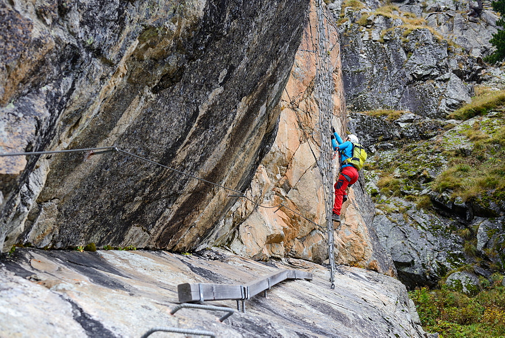 Woman climbing the via ferrata La Resgia, Engadin, Grisons, Switzerland