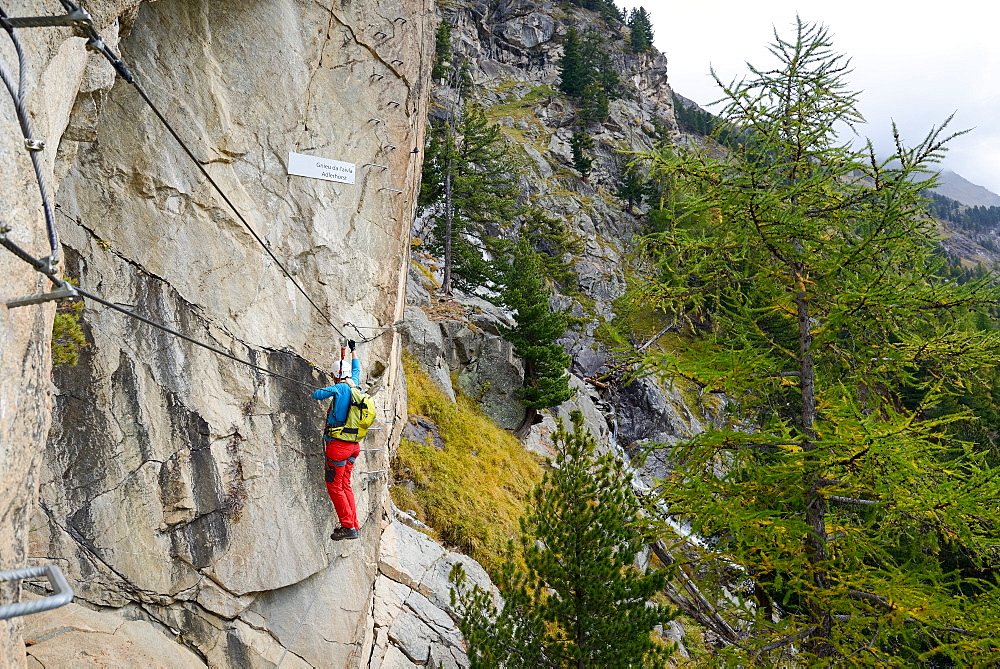 Woman climbing the via ferrata La Resgia, Engadin, Grisons, Switzerland