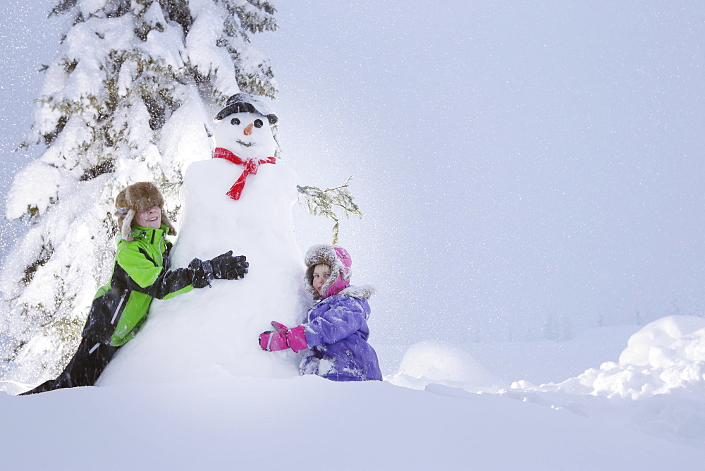 Children building a snowman, Passo Monte Croce di Comelico, South Tyrol, Italy