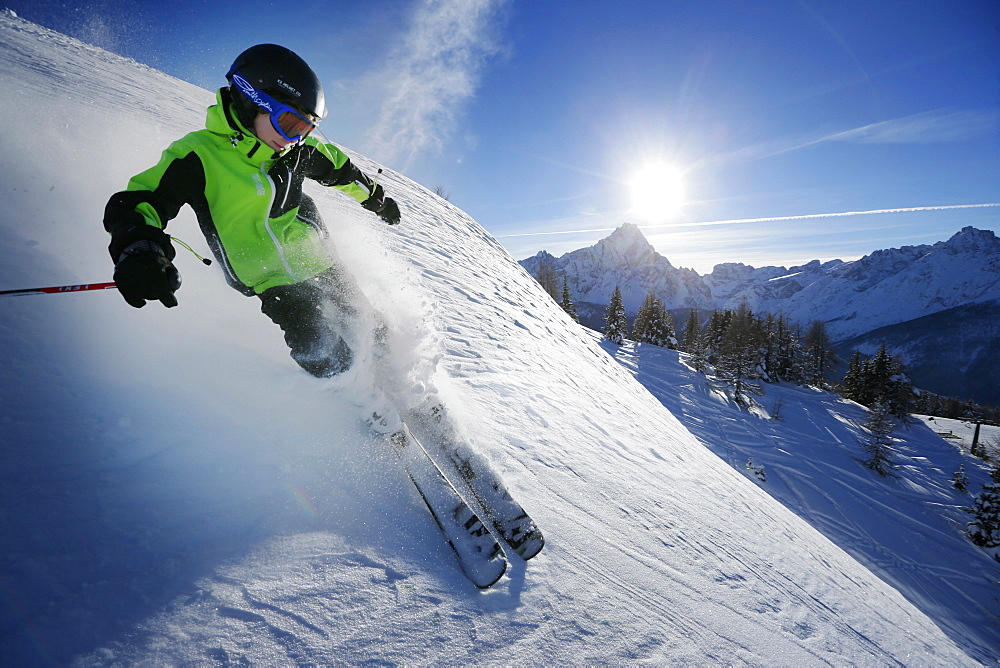 Boy downhill skiing from mount Helm (Monte Elmo), Sexten, South Tyrol, Italy