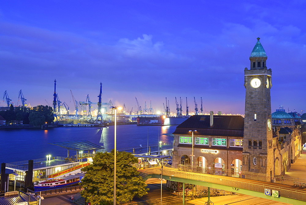 Illuminated St. Pauli-Landungsbruecken with Pegelturm and harbour in background, Landungsbruecken, Hamburg, Germany