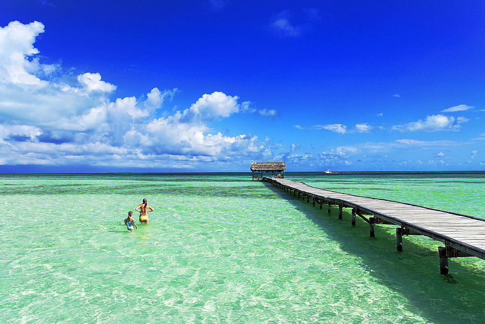 Mother and Daughter standing in water near jetty, Cayo Guillermo, Ciego de Avila, Cuba, West Indies