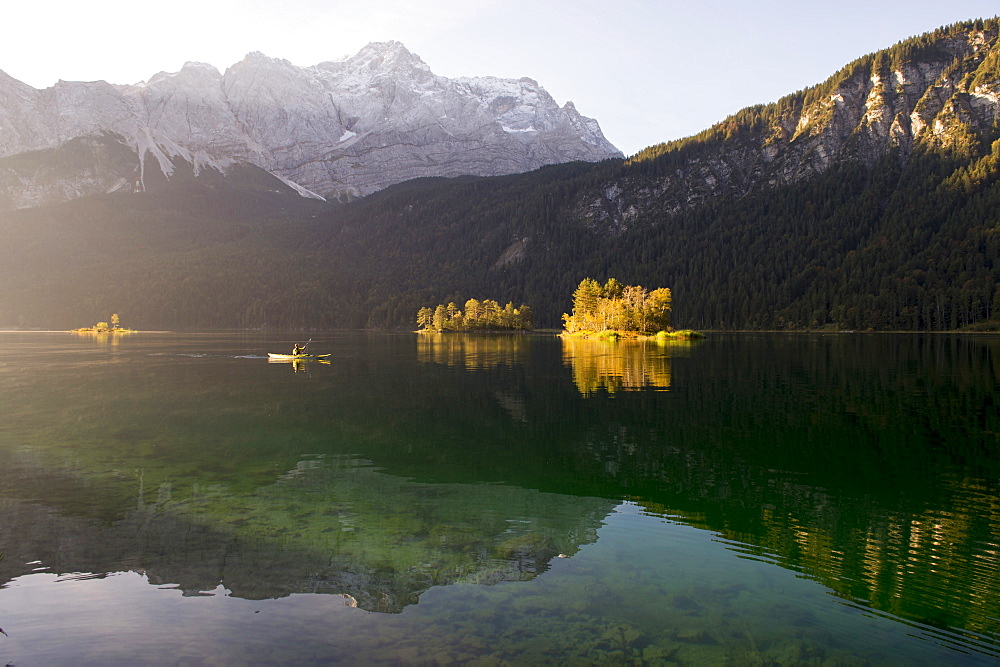 Kayaker paddling on the Eibsee below Zuspitze, Grainau, Bavaria, Germany