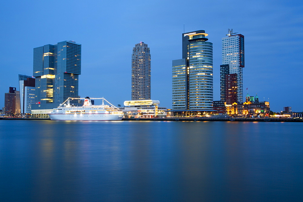 Cruise ship MS Deutschland (Reederei Peter Deilmann) at Rotterdam Cruise Terminal on Nieuwe Maas river with high-rise buildings 