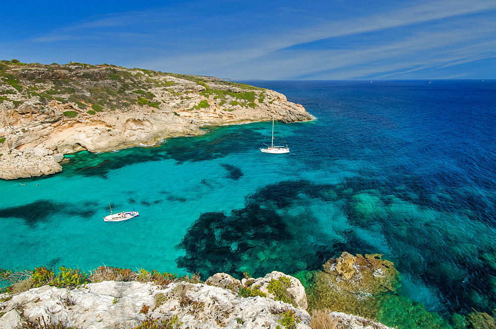 A sailing yacht and a fishing boat anchored in a lonely bay with clear blue water, Mallorca, Balearic Islands, Spain, Europe