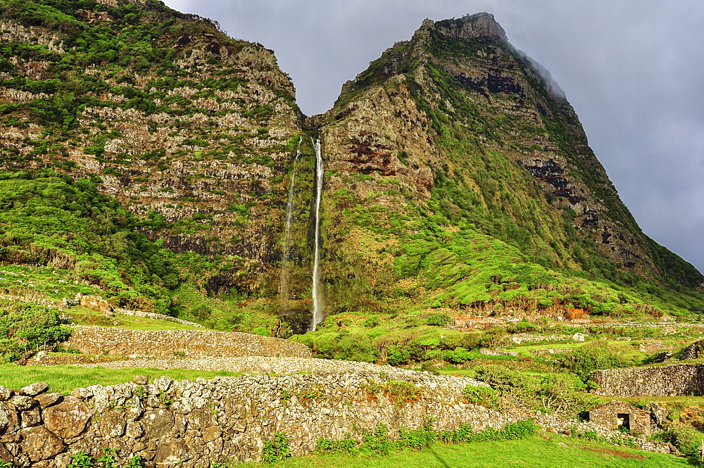 Waterfall Poco do Bacalhau, mountains and abandoned stone houses, Faja Grande, Island of Flores, Azores, Portugal, Europe, Atlantic Ocean