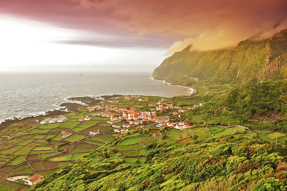 sunset and dramatic clouds over Faja Grande with terraces fields, white houses and steep coast, Island of Monchique in the sea, westermost point of Europe, view from the old whale outlook, Island of Flores, Azores, Portugal, Europe, Atlantic Ocean