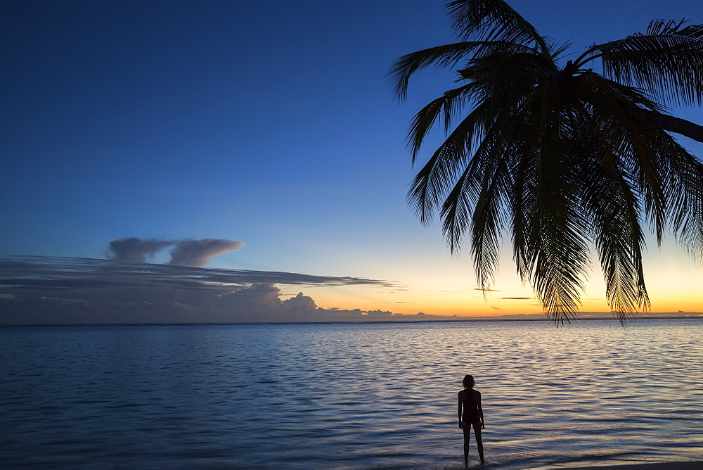 Woman at sunrise at Meeru Island Resort, Meerufenfushi, North-Male-Atoll, Maldives