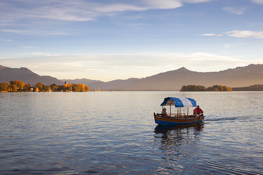 Couple in a boat, view to Fraueninsel, near Gstadt, Chiemsee, Chiemgau region, Bavaria, Germany