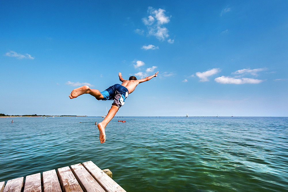 Boy diving from a pier, South beach, Burgtiefe, Fehmarn island, Baltic Coast, Schleswig-Holstein, Germany