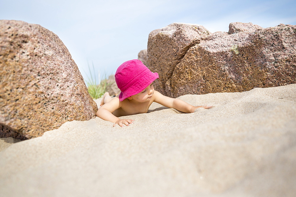 Little girl with sun hat playing on the beach, summer, holiday, family, Baltic sea, MR, Bornholm, Sandvig, Denmark, Europe