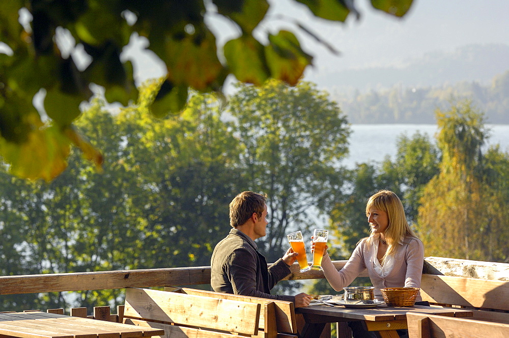 Young couple at a beer garden in the sunlight, lake Tegernsee, Bavaria, Germany, Europe