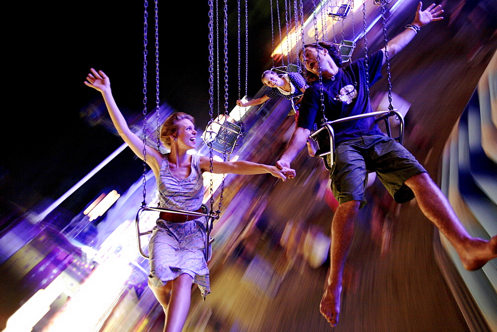 young people are having fun in a roundabout, Kaufbeuren, Bavaria, Germany