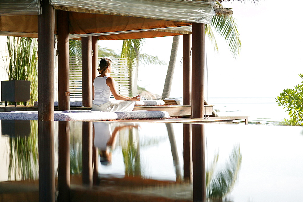 Woman meditating by a pool, Reflection in the water, Relaxation, Wellness, Health