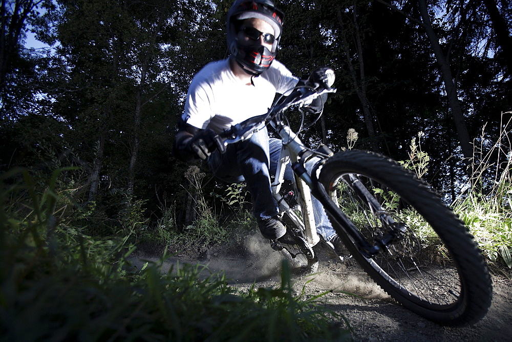 Mountain biker riding over forest track, Oberammergau, Bavaria, Germany