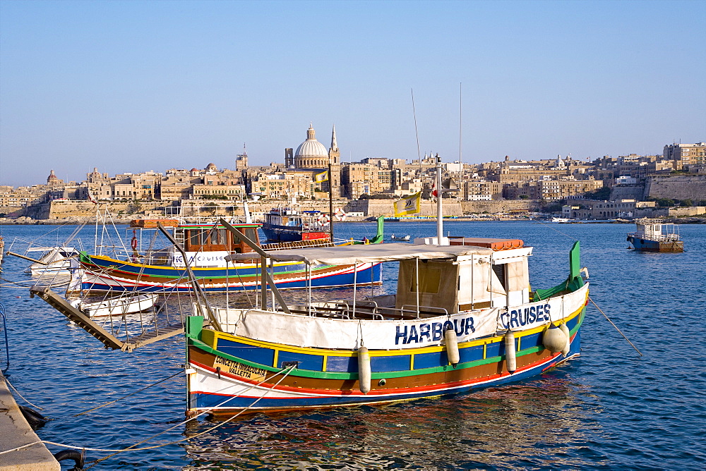 Colourful excursion boat at Marsamxett Harbour with view at the town Valletta, Sliema, Malta, Europe