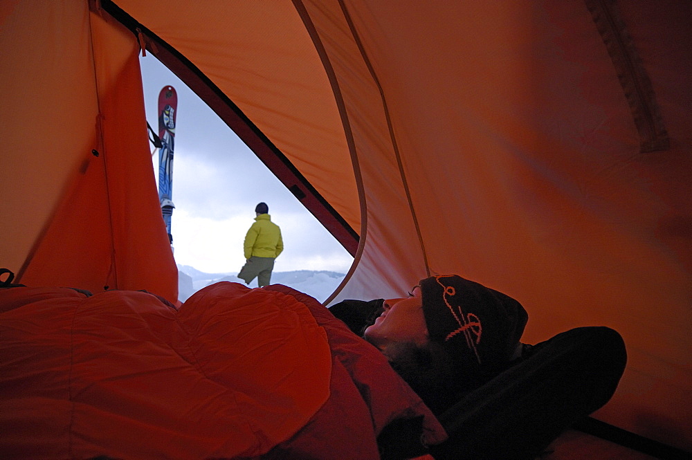 Woman inside a tent looking outside, Camping in Winter at Hochgrat, Allgäu Alps, Bavaria, Germany, Europe