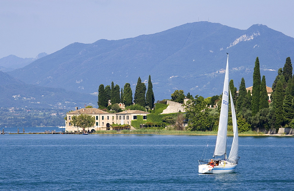 Boat sailing to Punta San Vigilio near Garda. The hotel is the oldest on lake Garda, Verona province, Veneto, Italy