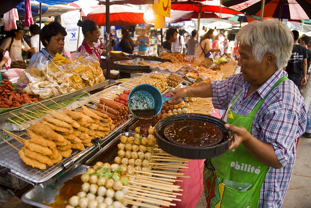 Woman preparing Thai food at Suan Chatuchak Weekend Market, Bangkok, Thailand