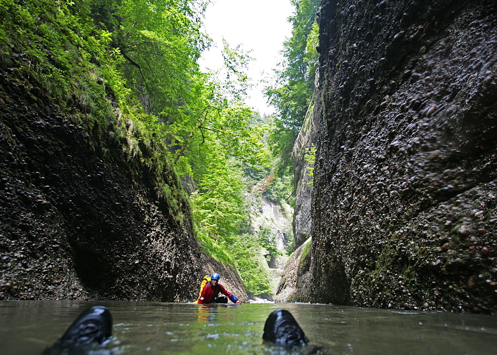 Men glinding through river, swim and hike canyon Raebloch, Emmental valley, Canton of Bern, Switzerland, MR