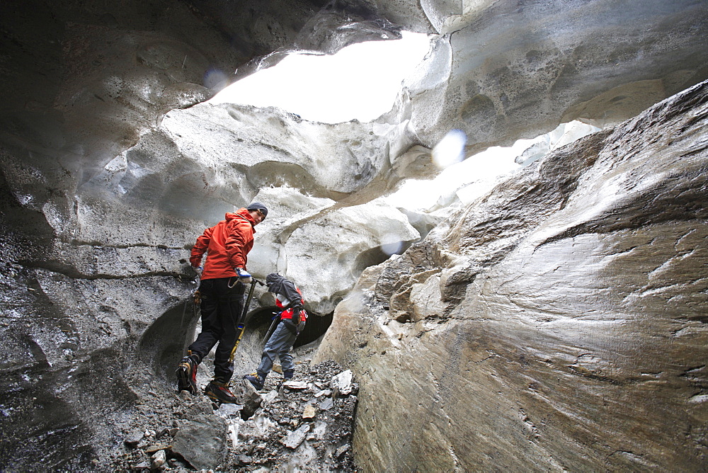 Two women inside a glacier cave, Brunegg Glacier, Canton of Valais, Switzerland, MR