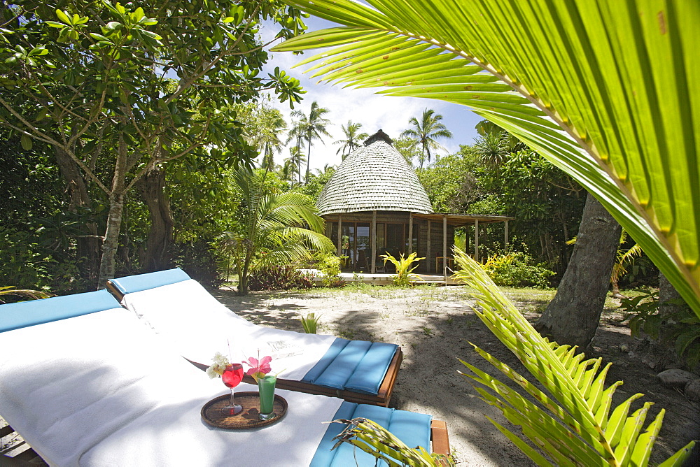 deck chairs and drinks in the garden in front of a traditional Fale, Tonga, South Seas