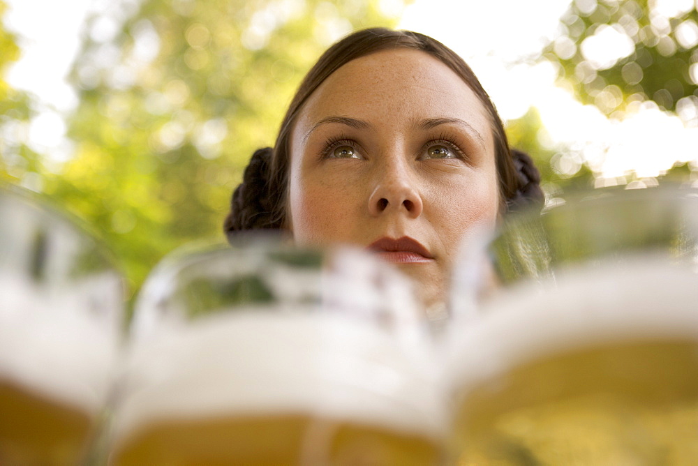 Waitress with beer steins in beer garden, Munich, Bavaria