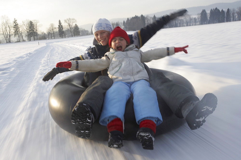 Girl and boy snowtubing