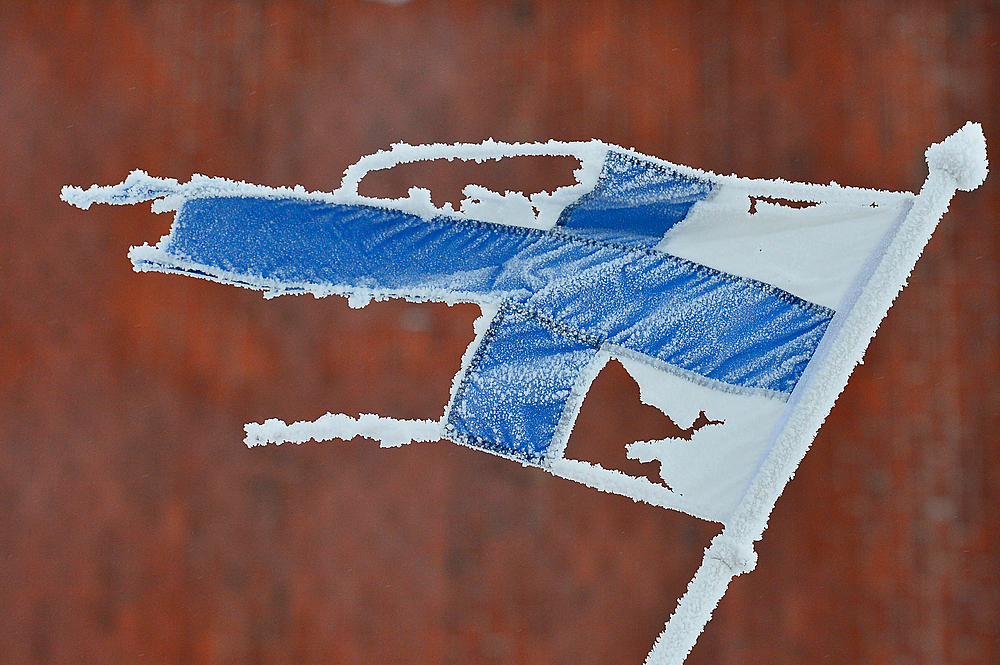 Iced and broken flag of Finland in winter, Dorotea, Lapland, Sweden