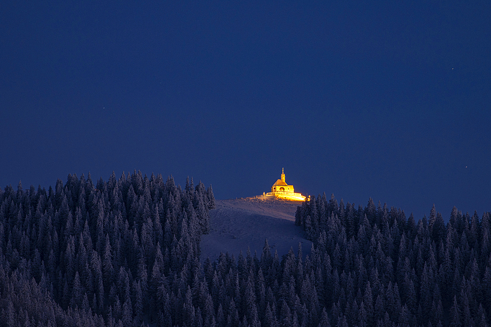 Illuminated Wallbergkirchlein Holy Cross with the paraglider launch site in the foreground, Tegernsee, Rottach-Egern, Upper Bavaria, Bavaria, Germany.