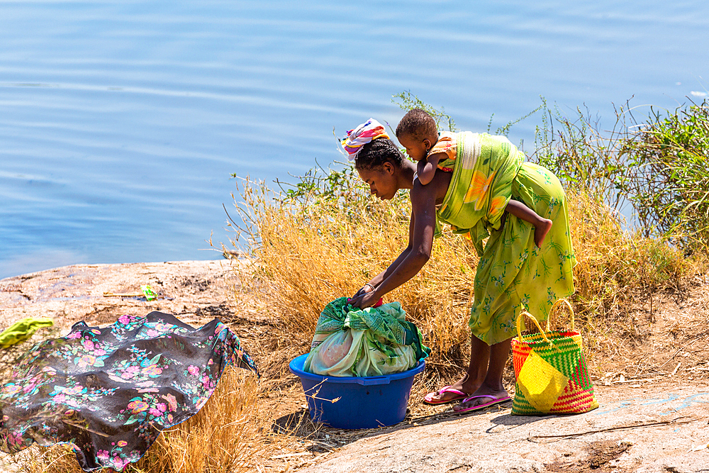 Woman with baby washing clothes by the river, Southern Madagascar, Africa