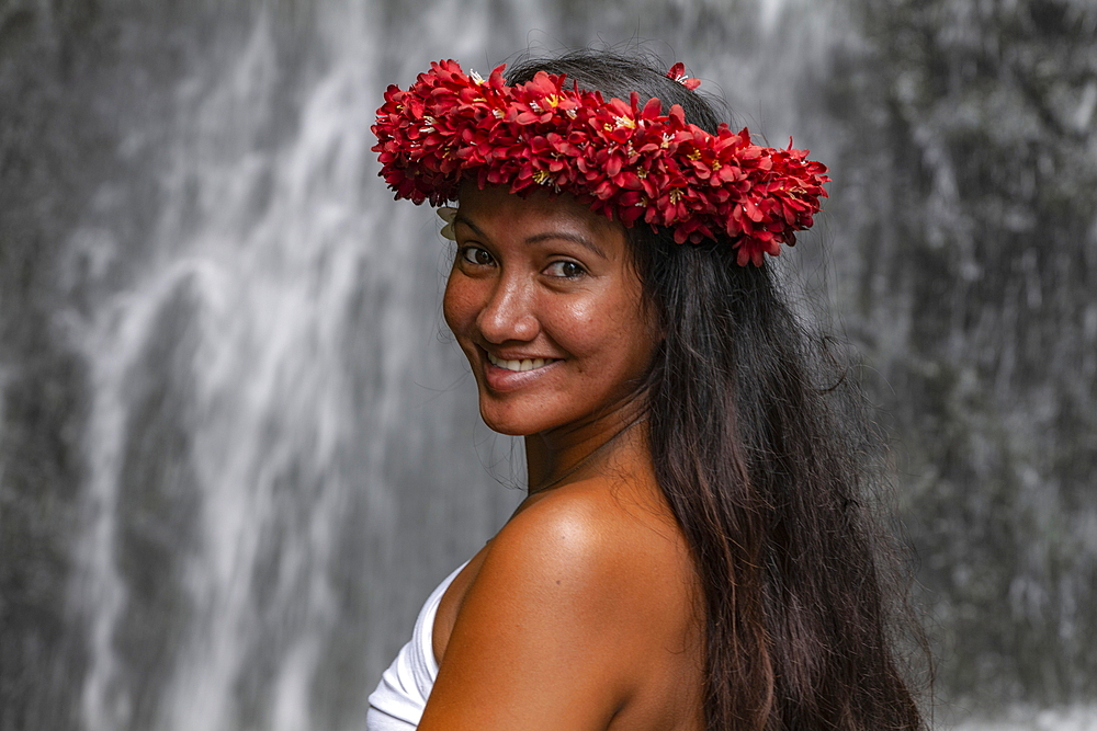 Portrait of a pretty young Tahitian woman with flower headdress in front of waterfall in 'The Water Gardens of Vaipahi', Teva I Uta, Tahiti, Windward Islands, French Polynesia, South Pacific