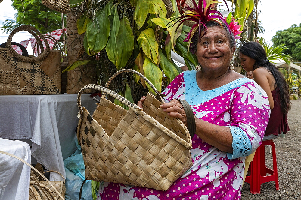 Portrait of a Tahitian woman with a bag traditionally woven from pandanus fibers at a cultural festival, Papeete, Tahiti, Windward Islands, French Polynesia, South Pacific