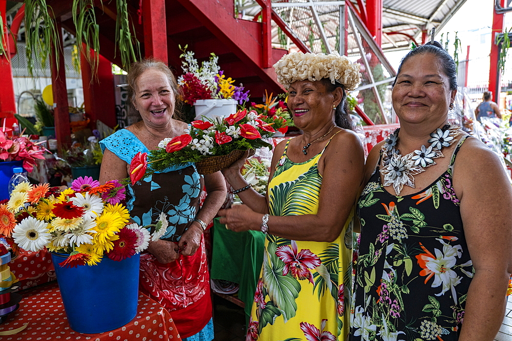 Three Tahitian women at a flower stand in the 'Marché Papeete' market hall, Papeete, Tahiti, Windward Islands, French Polynesia, South Pacific