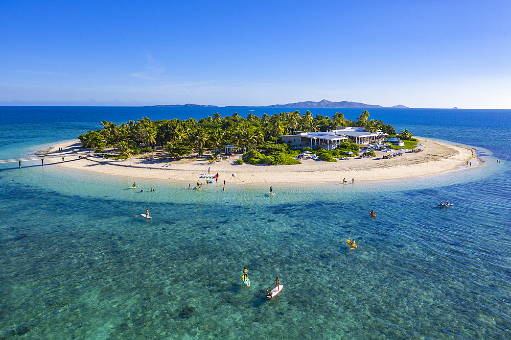 Aerial view of people on SUP stand up paddle boards at Malamala Island Beach Club, Mala Mala Island, Mamanuca Group, Fiji Islands, South Pacific