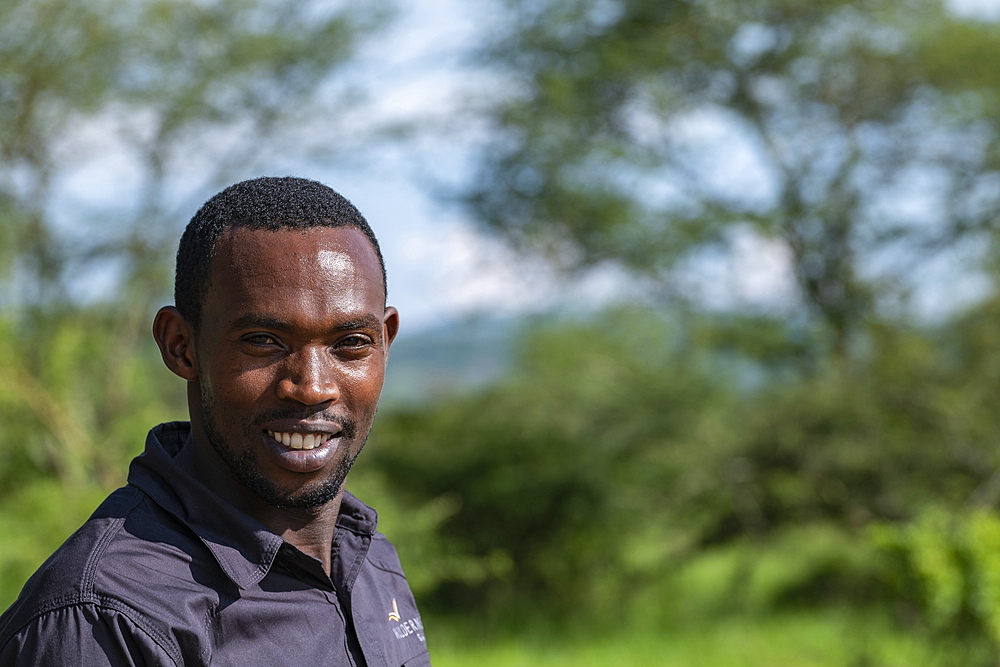 Smiling driver of a safari vehicle operated by luxury resort tented Magashi Camp (Wilderness Safaris), Akagera National Park, Eastern Province, Rwanda, Africa