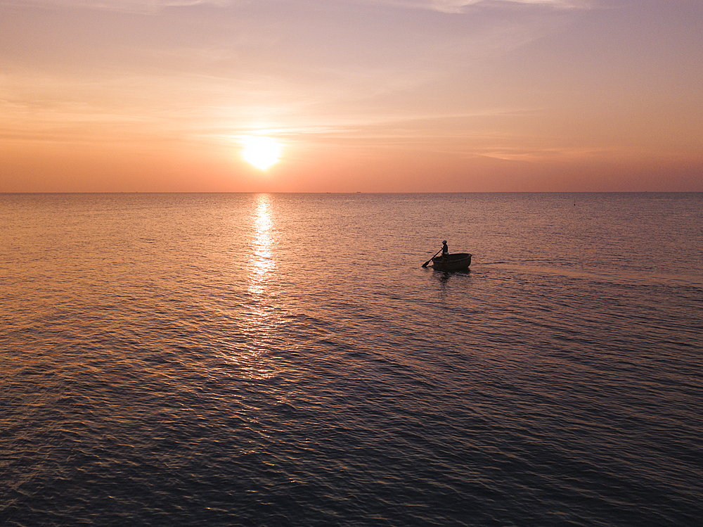 Aerial view silhouette of fisherman in traditional round boat at sunset, Ong Lang, Phu Quoc Island, Kien Giang, Vietnam, Asia