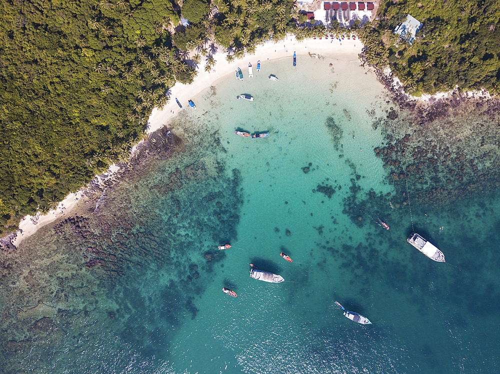 Aerial view of fishing boats moored in bay and beach with coconut palms, May Rut Island, near Phu Quoc Island, Kien Giang, Vietnam, Asia