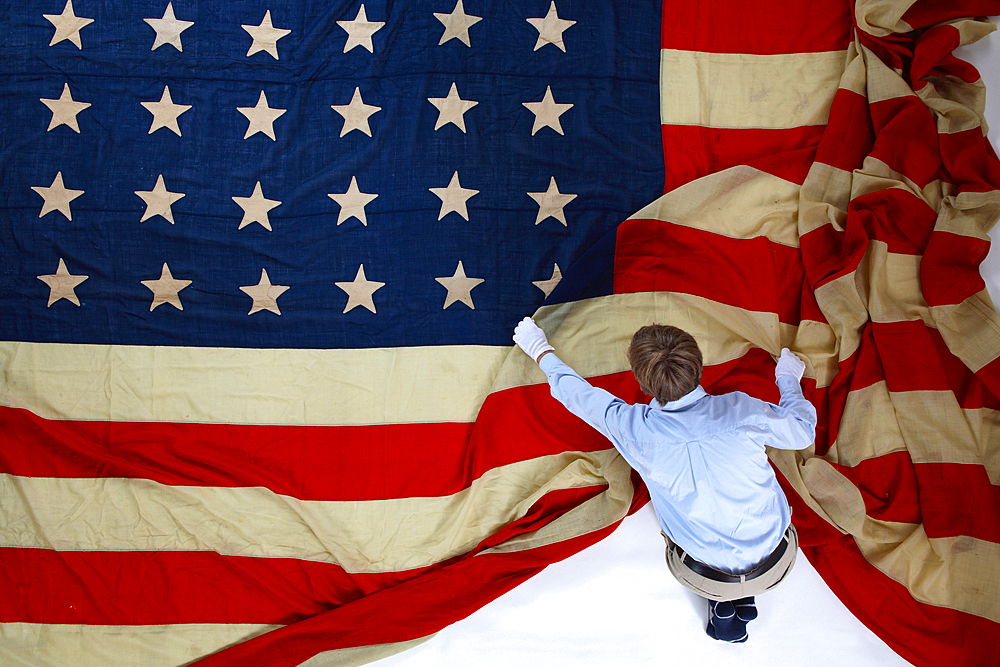 A man folding out a giant American flag. Shot in Texas, USA.