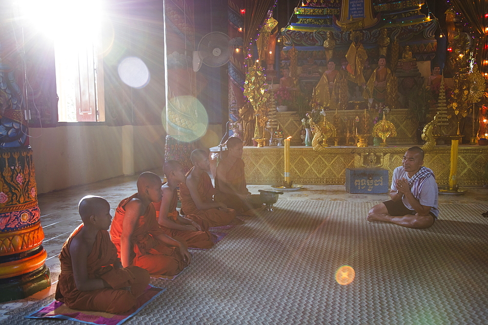 Guide from river cruise ship prays with Buddhist monks in the temple, Preah Prosop, Mekong River, Kandal, Cambodia, Asia